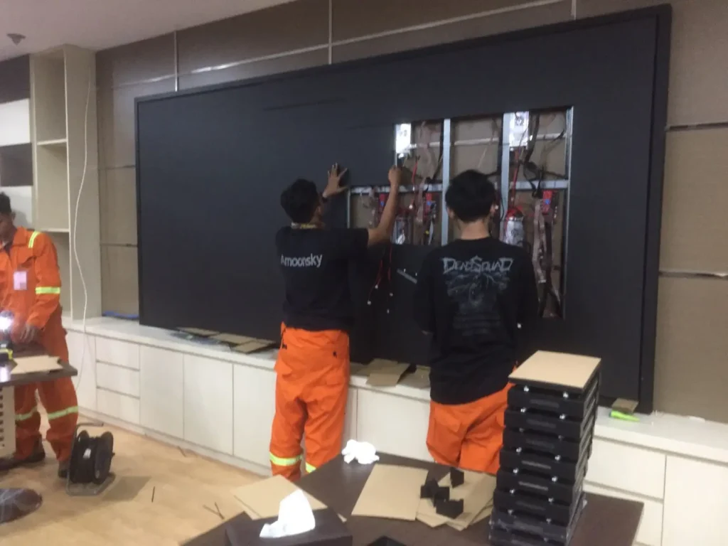 Tim teknisi CCTVSurabaya.com melakukan tahap finishing pemasangan modul LED Videotron Indoor di dinding ruang rapat kantor area Surabaya.