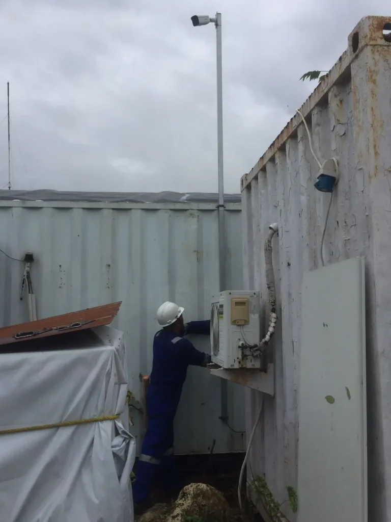 Pemasangan tiang CCTV Outdoor di samping kontainer kantor lapangan (Direksi Keet) pada lokasi proyek konstruksi di Surabaya untuk pemantauan keamanan aset material.