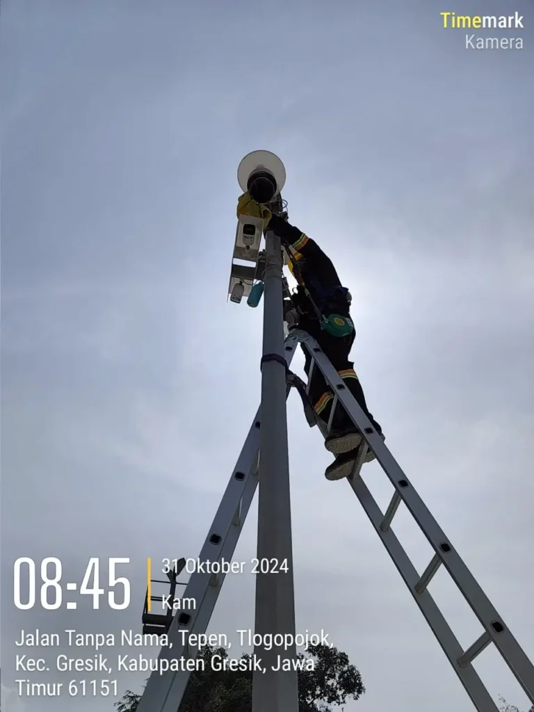 Teknisi CCTVSurabaya.com melakukan maintenance kamera CCTV Outdoor di ujung tiang tinggi menggunakan tangga ekstensi di area Tepen, Tlogopojok, Kabupaten Gresik.