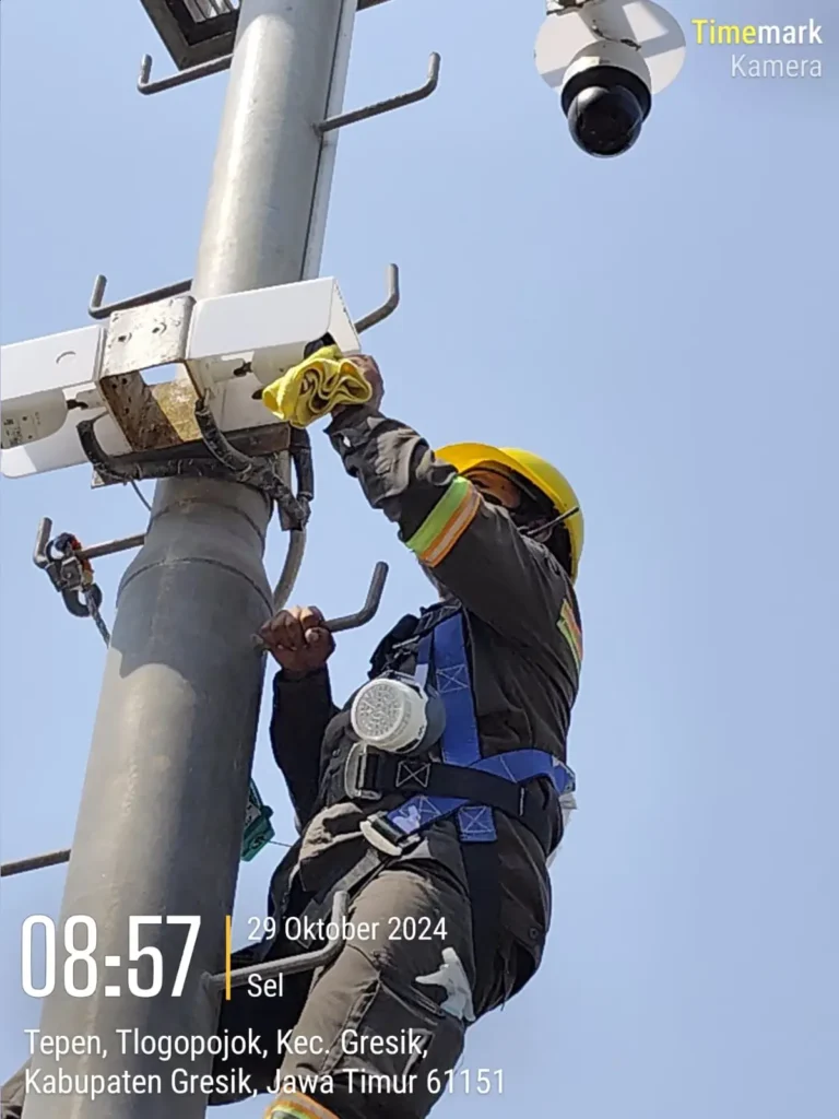 Teknisi CCTVSurabaya.com dengan APD lengkap (Full Body Harness) melakukan perawatan perangkat jaringan wireless CCTV di tiang area Tepen, Tlogopojok, Kabupaten Gresik.