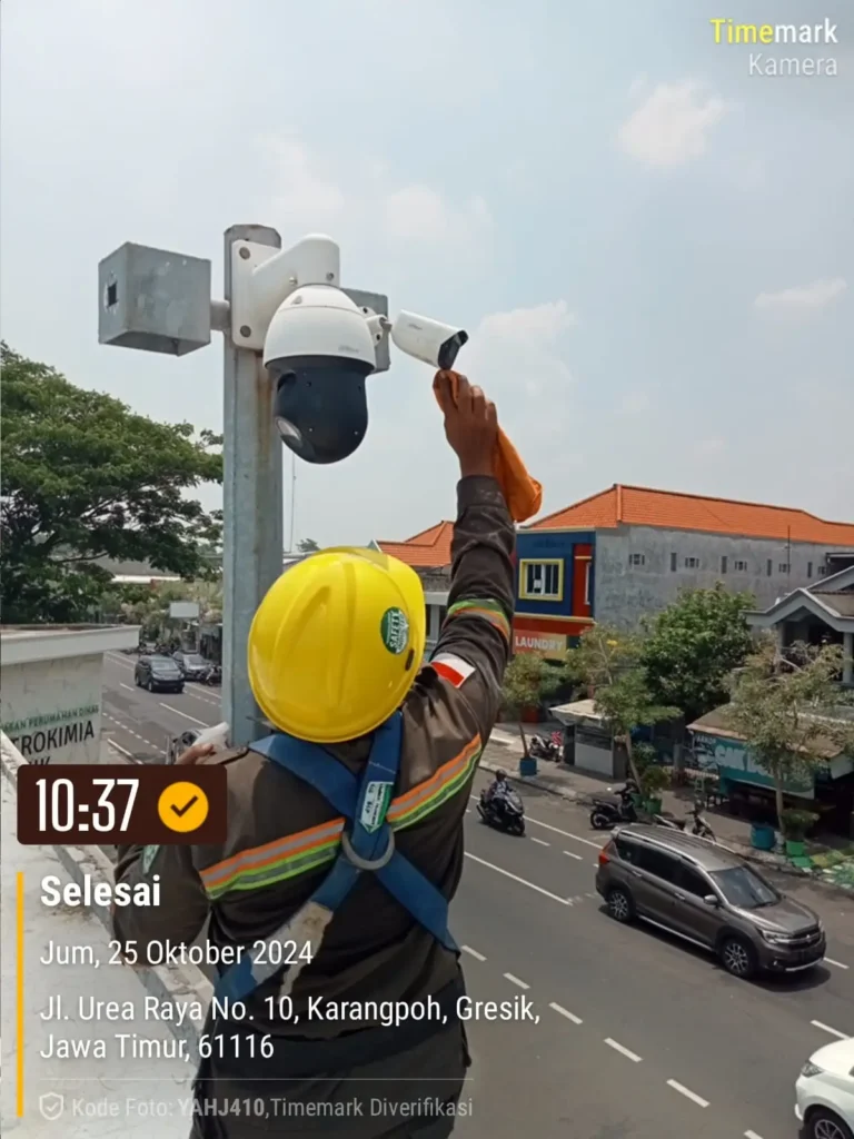 Teknisi CCTVSurabaya.com dengan alat pelindung diri (APD) lengkap melakukan pembersihan lensa dan maintenance kamera CCTV PTZ Outdoor di Jalan Urea Raya, kawasan Petrokimia Gresik.