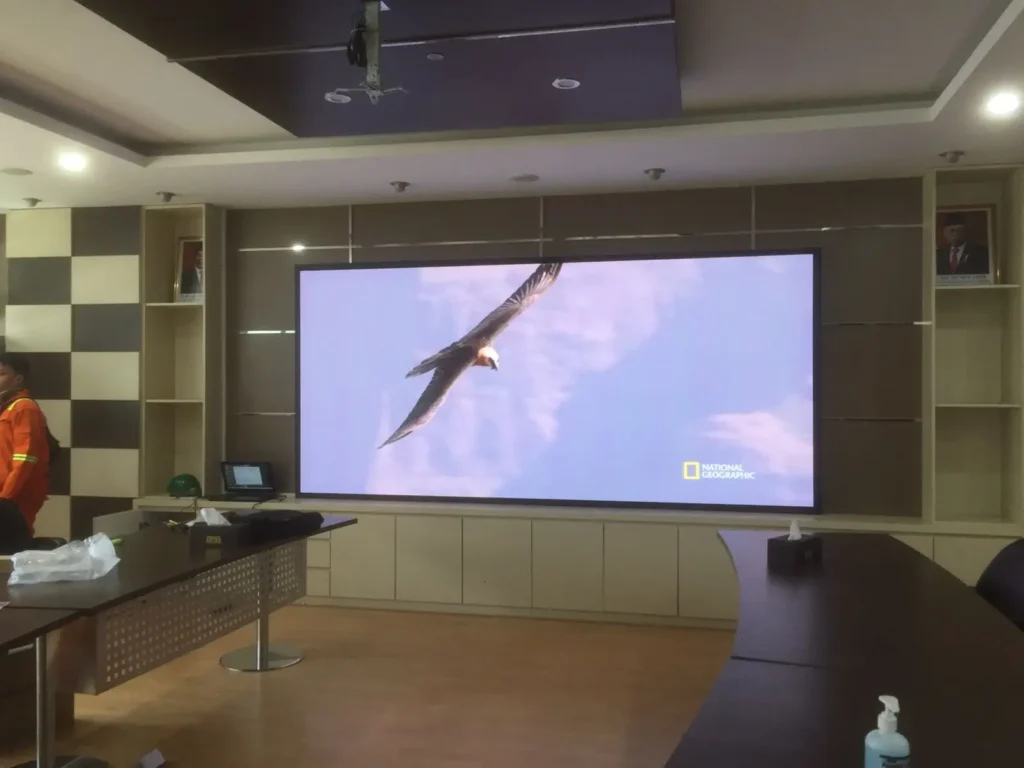 Tampilan layar Videotron Indoor resolusi tinggi menampilkan konten video jernih di ruang rapat kantor instansi Surabaya, hasil instalasi CCTVSurabaya.com.