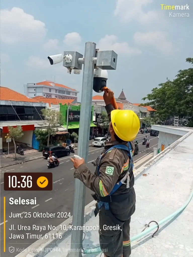 Teknisi CCTVSurabaya.com sedang membersihkan kubah kamera PTZ Outdoor di tiang tinggi area Jalan Urea Raya, Karangpoh, Gresik, Jawa Timur.