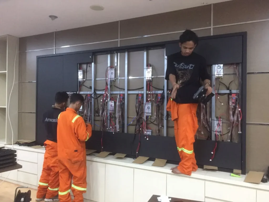 Tim teknisi CCTVSurabaya.com sedang merakit dan memasang modul LED Videotron Indoor pada rangka presisi di ruang meeting kantor instansi.