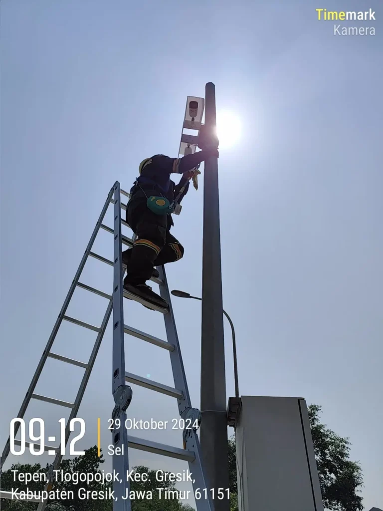 Teknisi CCTVSurabaya.com memanjat tangga melakukan perbaikan dan maintenance CCTV di tiang tinggi area Tepen, Tlogopojok, Kabupaten Gresik.